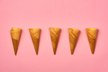 Empty ice cream cornet on pink background. Flat lay style.