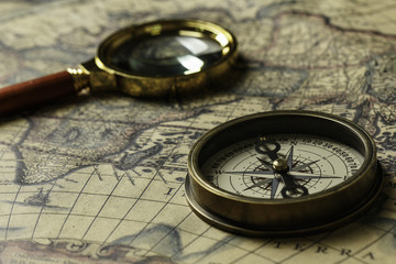 Fototapeta na wymiar Retro compass with old map and magnifier
