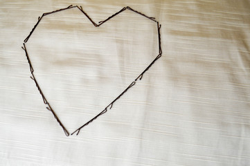 Heart from the hairpin-nebedymok on a beige background. The heart is made up of female ornaments.
