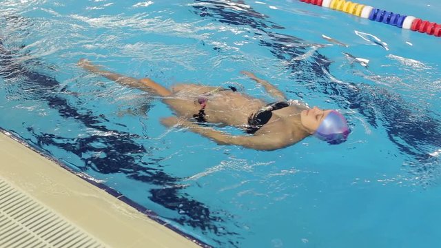 Slender athletic pregnant woman floating on back in pool. Pregnant woman, Swimming Pool, Health, fitness.