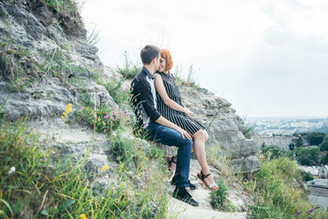 Naklejka na ściany i meble young woman sits with her boyfriend on the peak of the hill