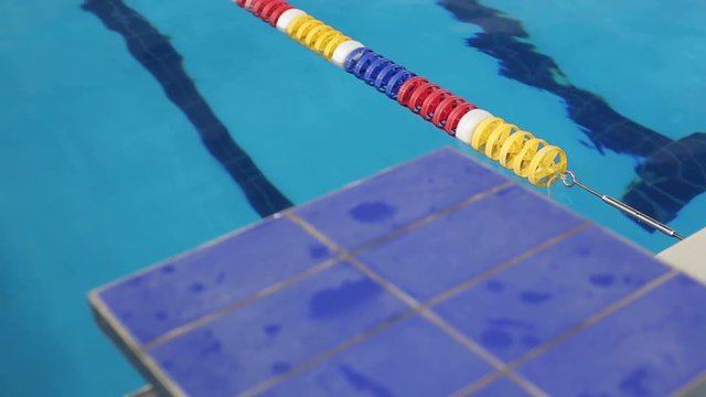Close-up view of diving board in swimming pool. A blue springboard for jumping into the water in the pool.