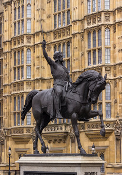 Sword raised in the air astride a prancing horse, Richard the Lion Heart is depicted outside of the British Parliament building.