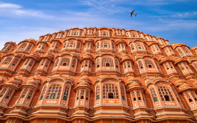 Airplane flies over historic Hawa Mahal palace at Jaipur, Rajasthan India.