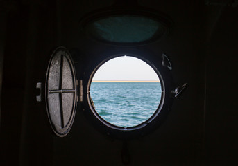 ship porthole on wooden wall