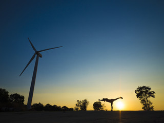 Woman do yoga pose on the mountain during sunset