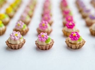 A lot of artificial cupcakes on white surface with shallow depth of field background.