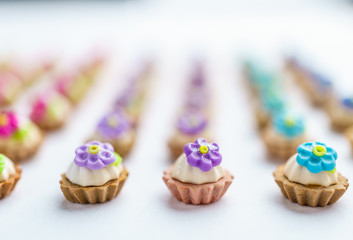 A lot of artificial cupcakes on white surface with shallow depth of field background.