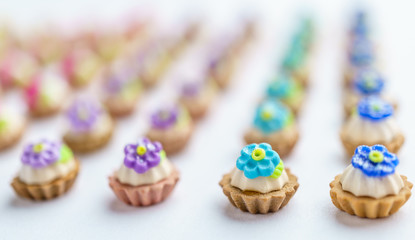 A lot of artificial cupcakes on white surface with shallow depth of field background.