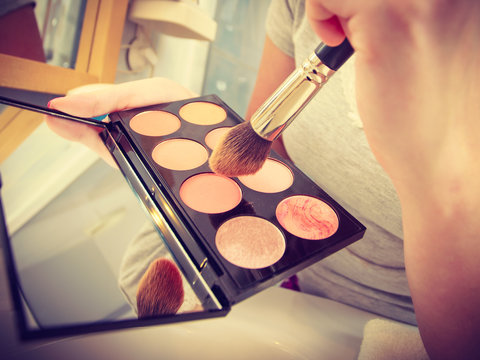 Woman In Bathroom Applying Contour Bronzer On Brush