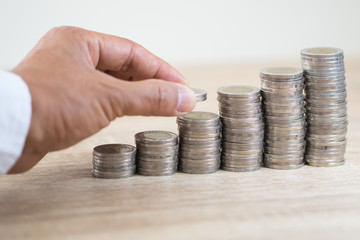 Saving money concept preset by Male hand putting money coin stack growing business
