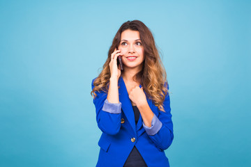 Smiling woman talking on the smart phone on blue background