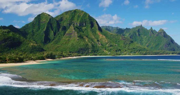Cinematic aerial view of dramatic mountains and beautiful ocean on North Shore of Kauai
