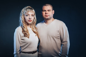 Man and woman in a white dresses lighted colored light in studio and black background