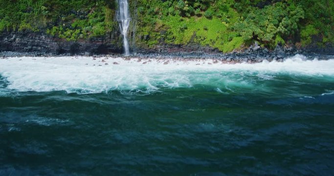 Cinematic aerial view of dramatic waterfall on sea cliff into the ocean
