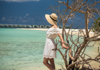 Girl in white dress on the beach. Maldives. Tropics. Vacation. Guraidhoo island.