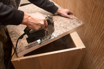 Master cuts wood with a jig saw