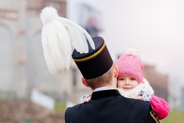 Black coal miner in gala uniform with his child.