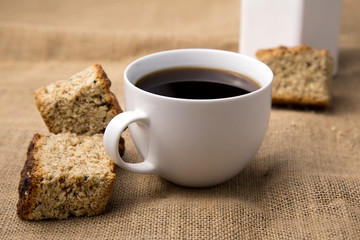 Cup of coffee with rusks and jug close-up