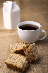 Cup of coffee with rusks and milk jug