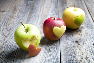 Apples with a cut heart on the wood