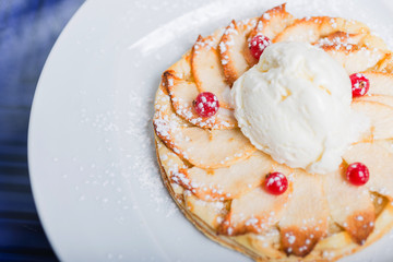Fresh fragrant cake apple strudel on a white plate with an ice cream ball.