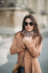 Stylish girl in coat posing for photographer