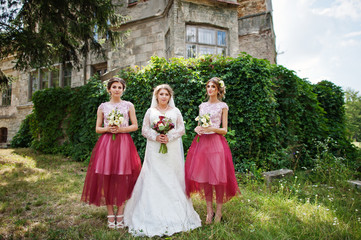 Happy bride and outgoing bridesmaids having fun on the wedding day next to a castle.