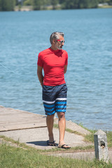 middle-aged man walking along the lake
