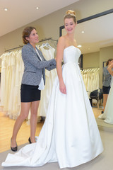 wedding dress designer assisting customer