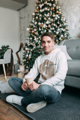 Fototapeta premium young handsome guy in the studio with a New Year theme, gay