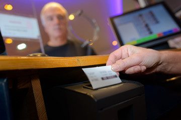 Ticket being printed from machine in booth