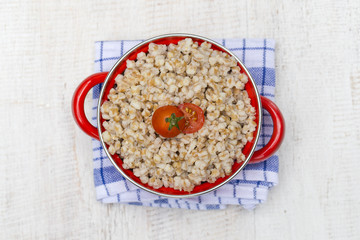 Red pan with wheat porridge - traditional meal in Ukraine, Belarus and Russia