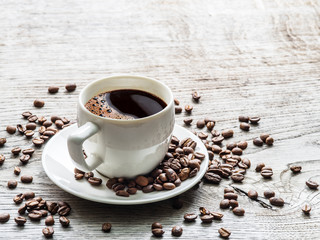Cup of coffee surrounded by coffee beans. Top view.