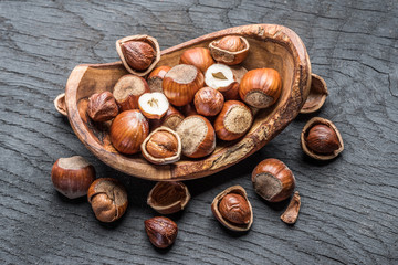 Filberts or hazelnuts in the wooden bowl on the table.
