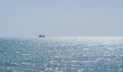 Calm glittering sea and cloudless sky.