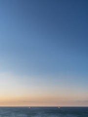 Calm sea and cloudless orange evening sky.