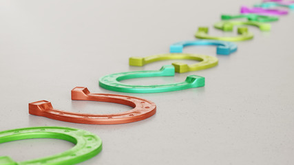 Line of Vibrantly Colored Horse Shoes on Simple Light Grey Surface