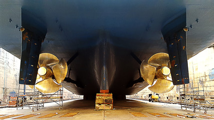 black ship hull and golden propeller at drydock