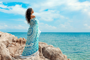beautiful young woman covered with blanket with on the beach