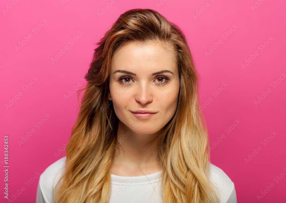 Poster Beautiful girl with long blonde hair on pink background