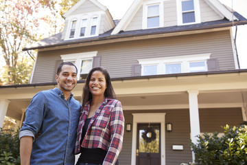 Portrait Of Smiling Couple Standing In Front Of Their Home