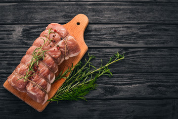Raw meat Beef fillet with rosemary and spices on a black wooden background. Top view. Free space...