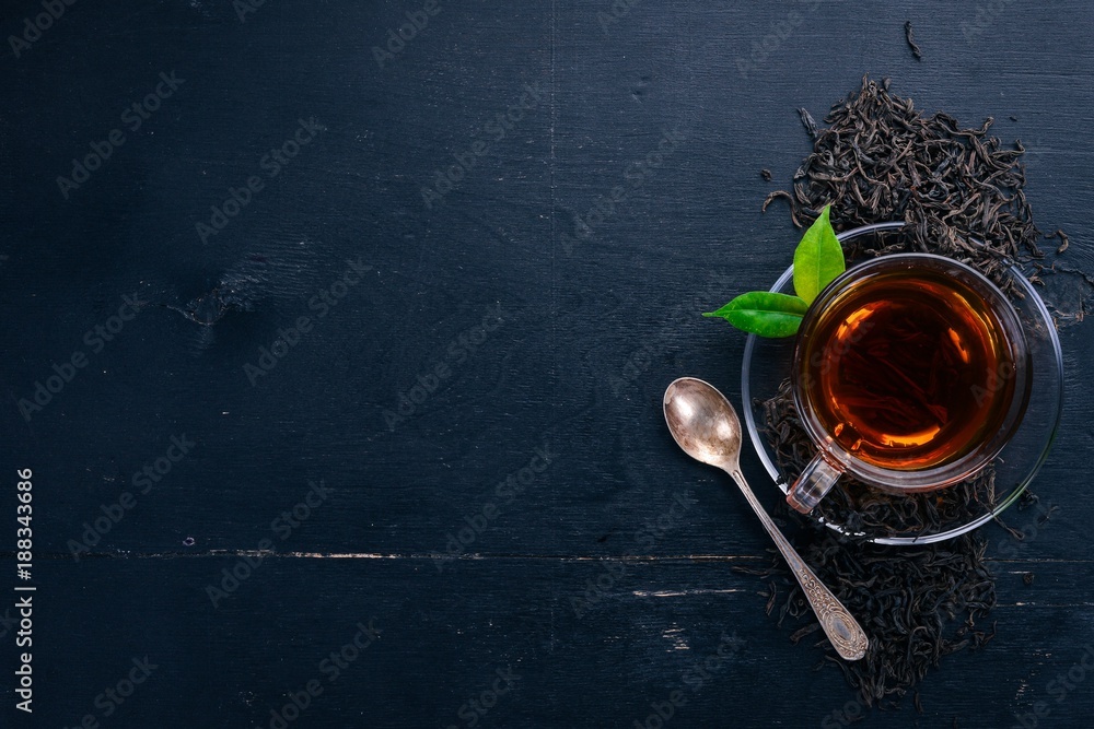 Wall mural a cup of black tea on a wooden background. top view. copy space.