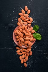 Almond nuts on a dark wooden background. Healthy snacks. Top view. Free space for text.