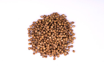 A pile of a  dry coriander seeds isolated on white background
