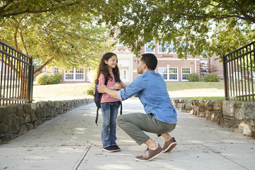 Father Dropping Off Daughter In Front Of School Gates