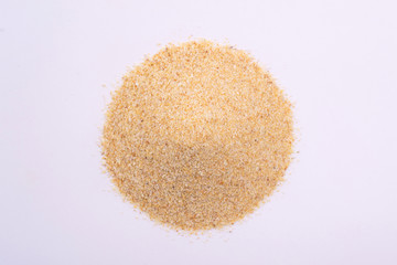 A pile of granulated garlic powder isolated on white background