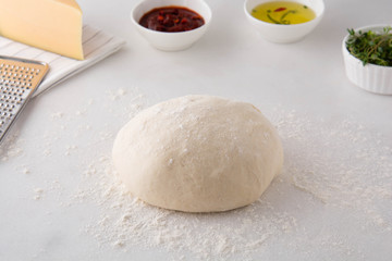 Fototapeta na wymiar Raw dough for pizza with ingredients.