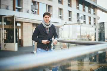 Man standing on the balcony and using smart phone.